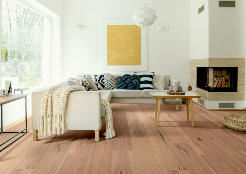 warm toned hardwood flooring in living room with white couch and contemporary decor.